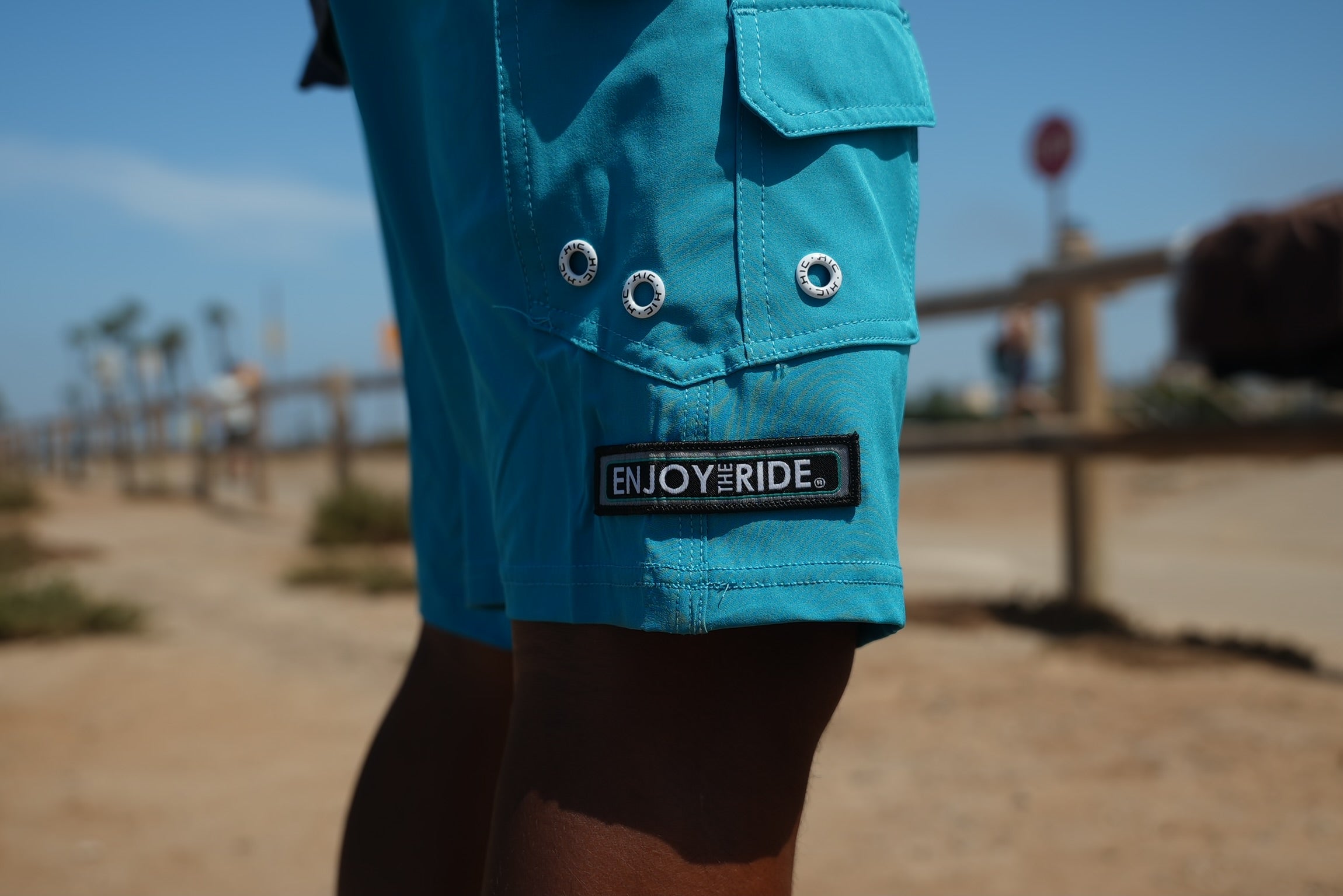 HIC ENJOY THE RIDE Generals Boardshorts in blue with floral pattern, displayed on a hanger against a neutral background.